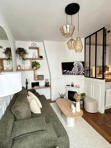 un salon avec un canapé et une table dans l'établissement Appartement proche Montmartre, à Paris