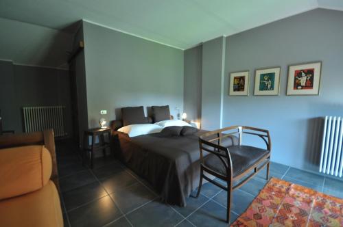 a bedroom with a bed and a chair and a couch at beppe country house in Asti