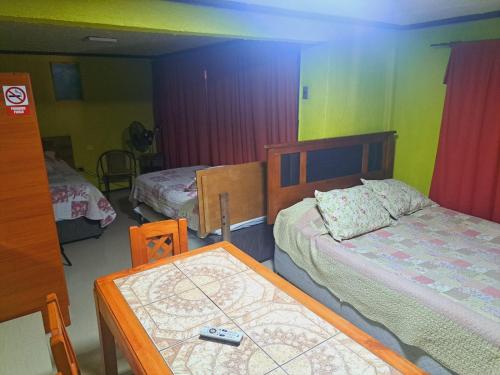 a room with two beds and a table in it at Hostal Inthalassa Caldera in Caldera