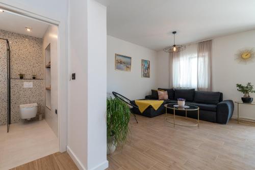 een woonkamer met een bank en een tafel bij Apartmani Dobrila Groundfloor II in Kaštel Novi