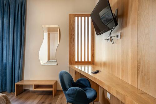 a living room with a chair and a television at Hotel Minerva in Siena