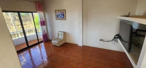 ein Wohnzimmer mit einem Stuhl und einem TV in der Unterkunft TAJ MAHAL THE IBERICO BEACH HOUSE in Caleta Grau