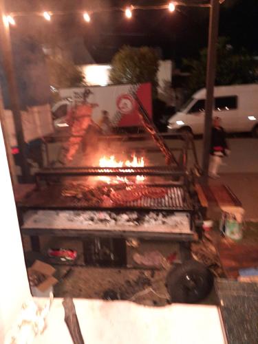 une personne prépare de la nourriture sur un grill dans l'établissement Hotel Octavio, à Itatí