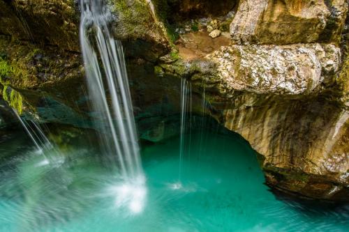 an aerial view of a waterfall in a pool of water at HOLIDAY HOUSE - River Bača in Most na Soči