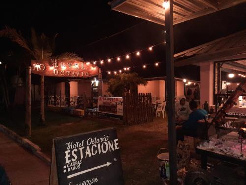 un restaurante con un cartel delante de él por la noche en Hotel Octavio en Itatí