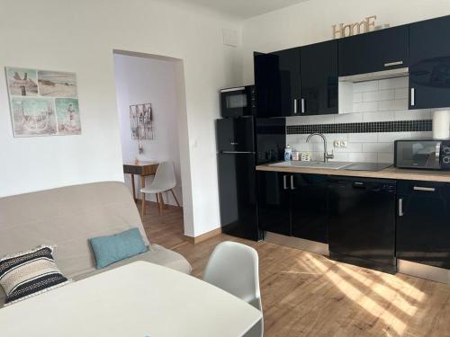 un salon avec un canapé et une cuisine dans l'établissement Appartement proche plage et commerces, à Royan