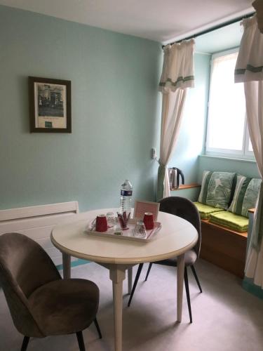 ein Wohnzimmer mit einem Tisch, Stühlen und einem Sofa in der Unterkunft Les chambres du Moulin in Les Epsailles