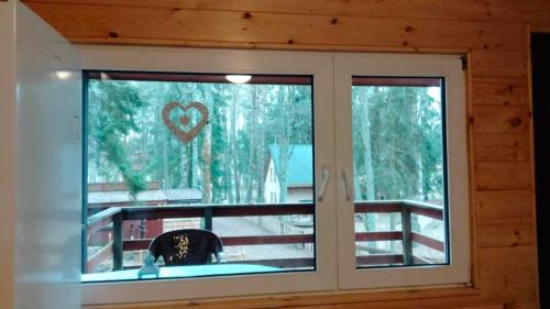 a window in a cabin with a heart on it at Oleandria-,, Domek Poziomeczka" nr 33 -ogrzewany w okresie jesienno-zimowym in Biskupiec