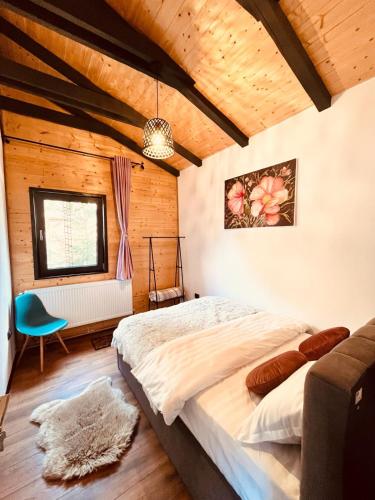 a bedroom with a large bed and a window at Kenzo Chalet in Porumbacu de Sus