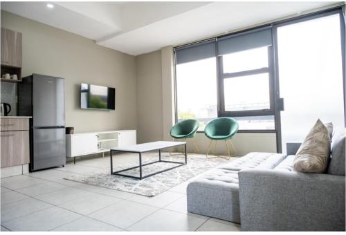 a living room with a couch and a table at The Bolton Rosebank Apartment 26 in Johannesburg