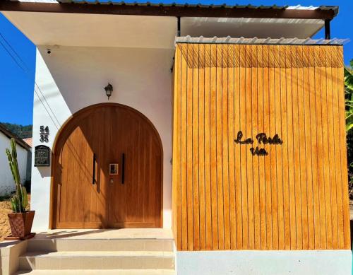 a wooden door on the side of a house at 2BR Pool Villa&Garden - Bali style by La Perla Phuket Rawai in Ban Saiyuan (1)