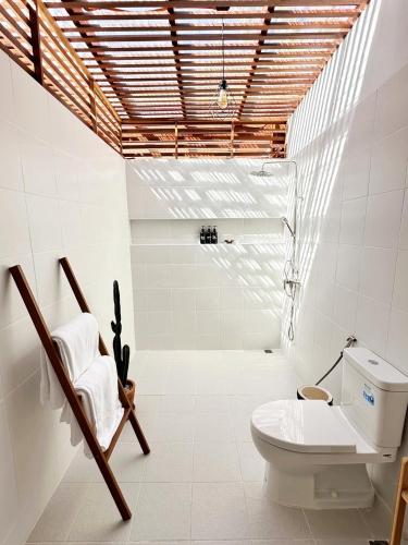 a bathroom with a toilet and a chair at 2BR Pool Villa&Garden - Bali style by La Perla Phuket Rawai in Ban Saiyuan (1)