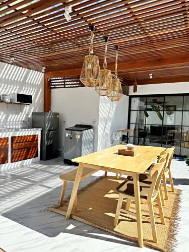 a wooden dining table and chairs in a kitchen at 2BR Pool Villa&Garden - Bali style by La Perla Phuket Rawai in Ban Saiyuan (1)