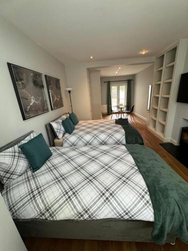 a large bedroom with a large bed with green pillows at Brentford Guest Rooms in Brentford