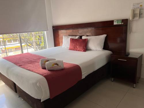 a bedroom with a large bed with two boxes on it at Hotel Dorado Gold in Bogotá