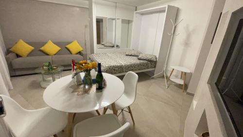 un salon avec une table et des chaises blanches dans l'établissement Charmant Studio - Centre ville de Cannes, à Cannes