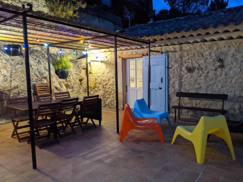 - un patio avec des chaises colorées et une table dans l'établissement La maison de Daniel - Esparron-de-Verdon, à Esparron-de-Verdon