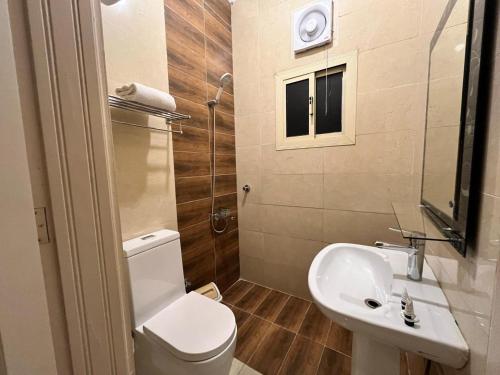 a bathroom with a toilet and a sink at Holiday Plus Al Salamh- هوليداي بلس السلامه in Jeddah
