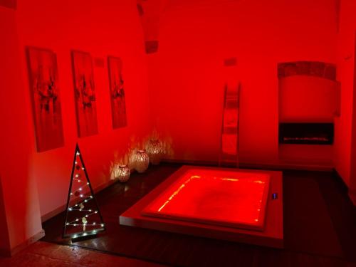 Chambre rouge avec une baignoire rouge et un arbre de Noël dans l'établissement Suite 87, à Mesagne