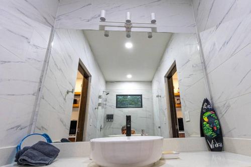 a bathroom with a large white sink and a mirror at Grande Espiritu 2 bedroom Casita, close to beach, 2 queen beds in Refundores