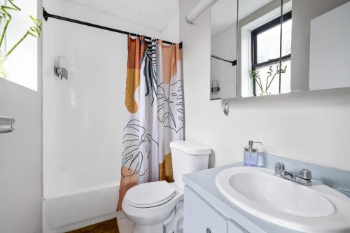 a white bathroom with a sink and a toilet at Experience the heart of Times Square in New York