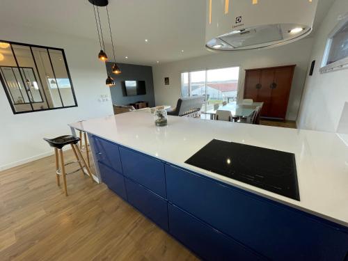 een keuken met een blauw en wit aanrecht bij Maison 10 personnes in Gragnague