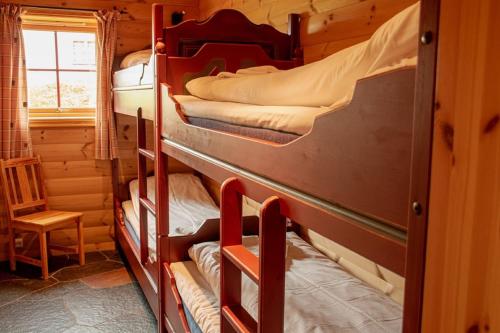 a room with three bunk beds in a cabin at Rondane Haukliseter Fjellhotell in Høvringen