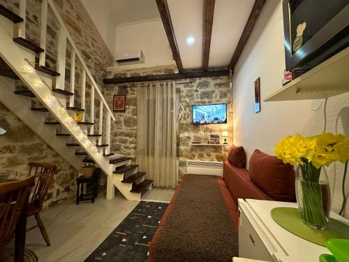 ein Wohnzimmer mit Sofa und Treppe in der Unterkunft Etno village Mihailovic II in Herceg-Novi