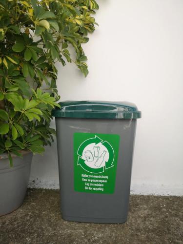 a green trash can with a peace sign on it at Nord Guesthouse in Néos Pírgos