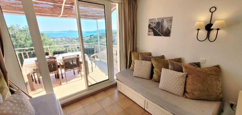 un salon avec un canapé et une grande fenêtre dans l'établissement Rare pearl with pool and beautiful sea view, à Grimaud