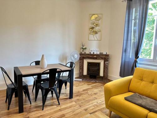sala de estar con mesa y sofá amarillo en Chez Delphine, en Bourg-en-Bresse