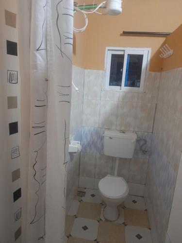 un piccolo bagno con servizi igienici e finestra di Prestige Guest House a Mariakani