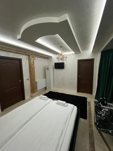 a bedroom with a large white bed in a room at pensiunea medellin in Tulcea