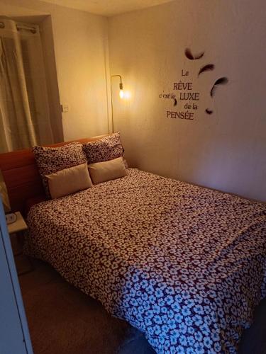 um quarto com uma cama com um edredão em Le first em Grasse
