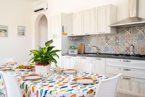 una cocina con una mesa con platos. en Villetta Rosa House 100 meters from the blue sea, en San Pietro in Bevagna