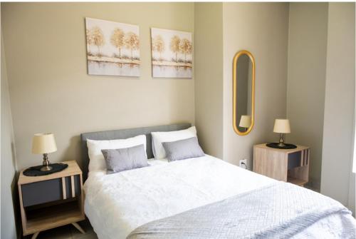 een slaapkamer met een bed en 2 tafels met lampen bij Rosebank Apartment the Bolton 27 in Johannesburg