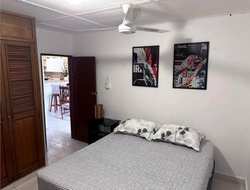 ein Schlafzimmer mit einem Bett und drei Bildern an der Wand in der Unterkunft Great Location, Apartment Close to the Malecón in Barranquilla