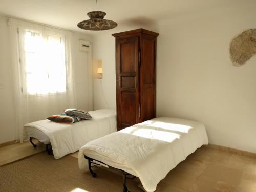 een kamer met 2 bedden, een kast en een raam bij La maison de Daniel - Esparron-de-Verdon in Esparron-de-Verdon