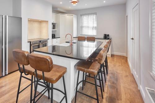 a kitchen with a large island with bar stools at Roslyn House in Pateley Bridge