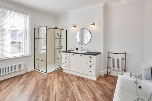 a white bathroom with a sink and a mirror at Roslyn House in Pateley Bridge