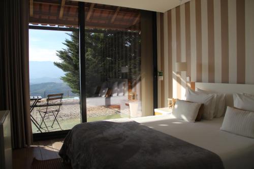 una camera da letto con un letto e una grande finestra di Quinta da Corujeira a Vila Real