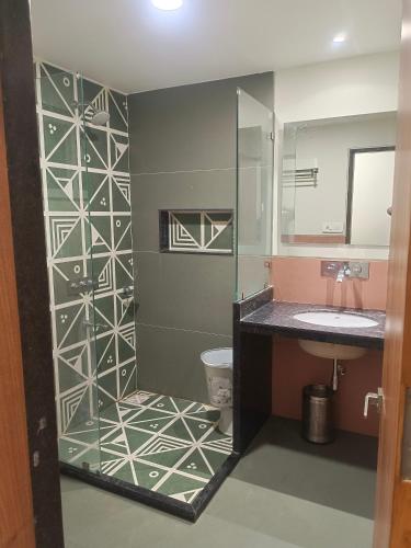 a bathroom with a shower with a toilet and a sink at Hotel Ashray in Ujjain