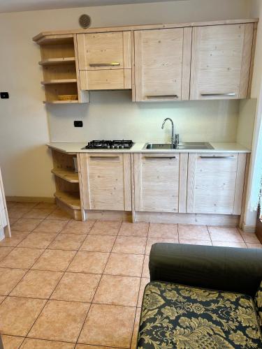 a kitchen with wooden cabinets and a sink at Residence Cima Tosa in Andalo