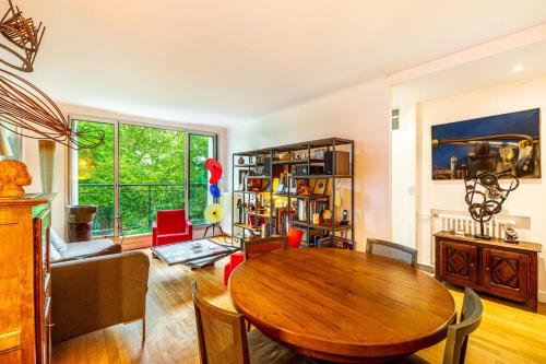 un salon avec une table en bois et un canapé dans l'établissement En face de Paris, les arbres, à Saint-Maurice