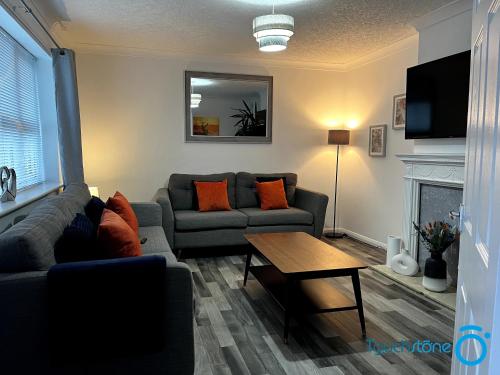 a living room with a couch and a table at Large Cosy Home - B'ham, Solihull, NEC, M42, HS2 in Birmingham