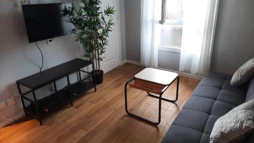 ein Wohnzimmer mit einem Sofa und einem Stuhl in der Unterkunft Appartement cosy Montreuil France in Montreuil