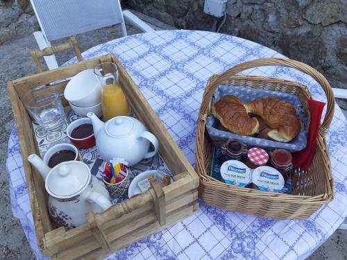 un cestino con croissant e tè e un cestino di croissant di Les Terrasses de Collanges a Saint-Pierre-de-Colombier