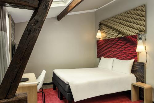 a hotel room with a bed and a table and a chair at ibis Paris Avenue de la Republique in Paris