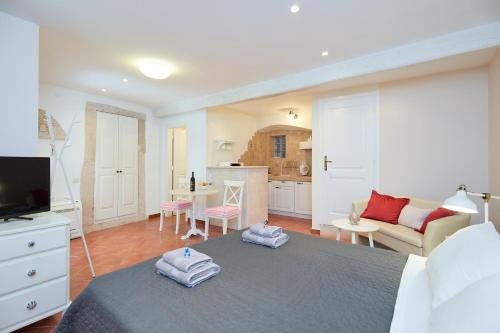 a bedroom with a bed and a living room at Doria Apartments in Dubrovnik