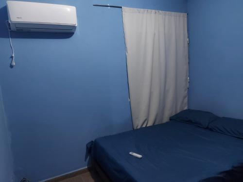 a blue room with a bed and a air conditioner at Verano infinito in Gualeguaychú